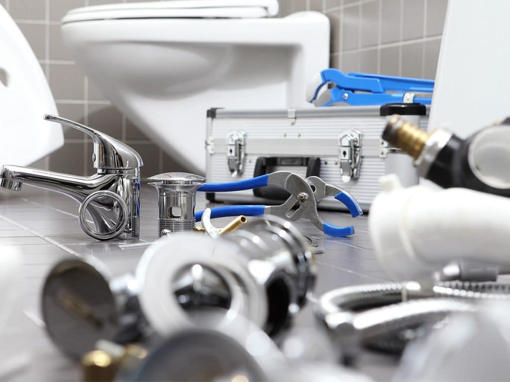 Plumbing tools on the floor of a bathroomm