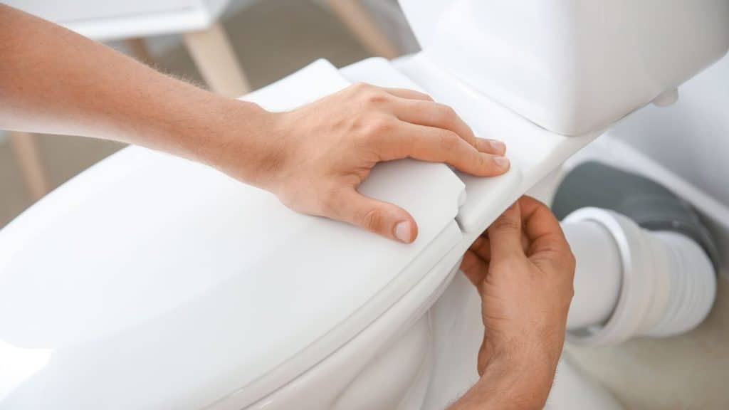 person fixing toilet