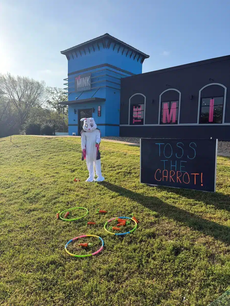 Easter bunny tossing carrots outside of The Mink Plumbing