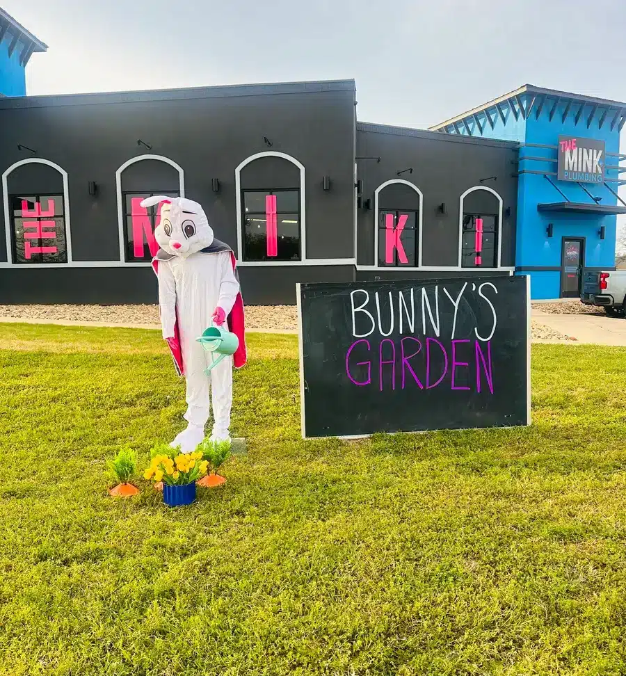 Easter bunny planting a garden outside of The Mink Plumbing