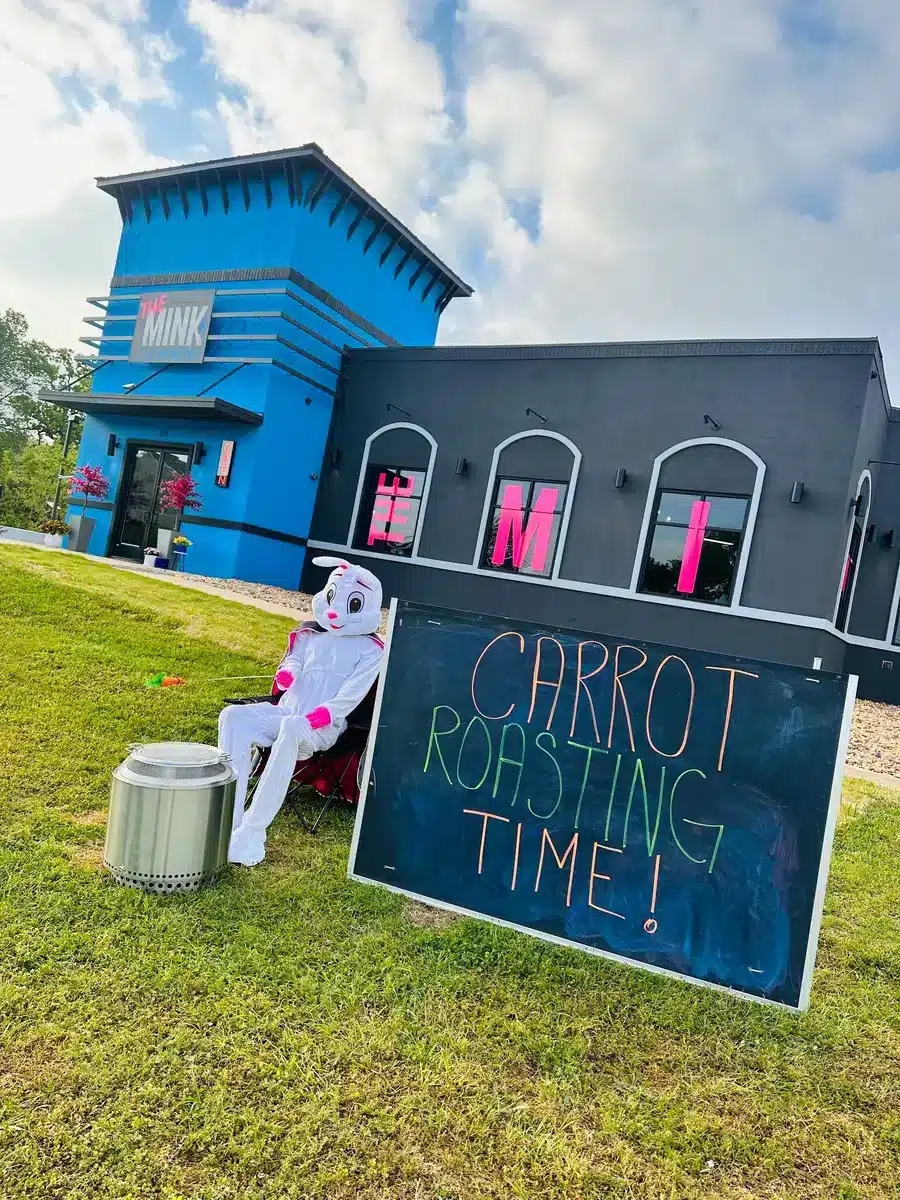 Easter bunny roasting carrots outside of The Mink Plumbing